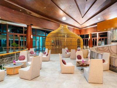 Moderní hotelová lounge s sochařským dřevěným pavilonem a bílými křesly