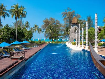 Langer Pool mit blauen Sonnenschirmen und Tropenpalmen im Hintergrund