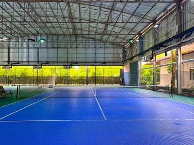 Court de tennis couvert avec surface bleue et toit en verre par jour ensoleillé