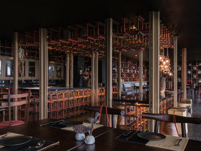 Przytulny bar hotelowy z drewnianym kontuarem, stołkami i ciepłą atmosferą w nocy.