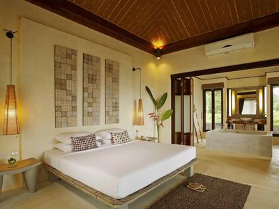 Modern ingerichte hotelkamer met groot bed, wanddecoratie en uitzicht op de badkamer.