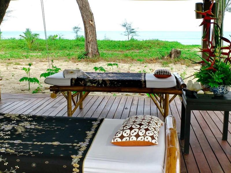 Ontspannende buitenspa tafel met uitzicht op groen landschap en strand.