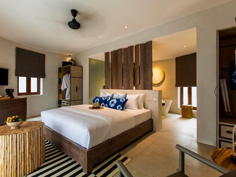 Moderne hotelkamer met tweepersoonsbed, houten decor en gezellige verlichting.