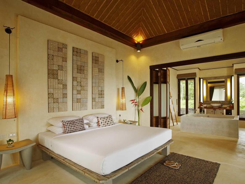 Modern ingerichte hotelkamer met groot bed, wanddecoratie en uitzicht op de badkamer.