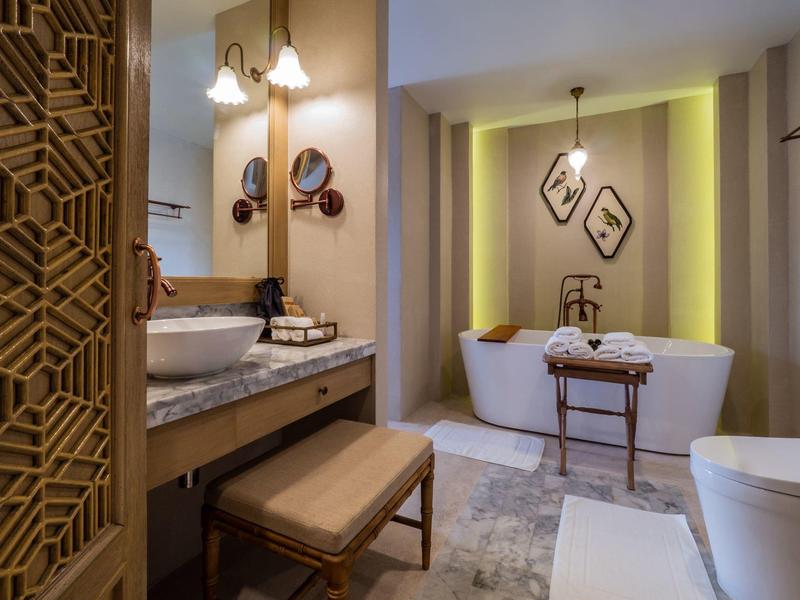 Salle de bain moderne avec baignoire autoportante, deux lavabos et tabouret