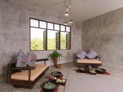 Area salotto rustica con mobili in legno, decorazioni floreali e tappeto in una stanza minimalista.