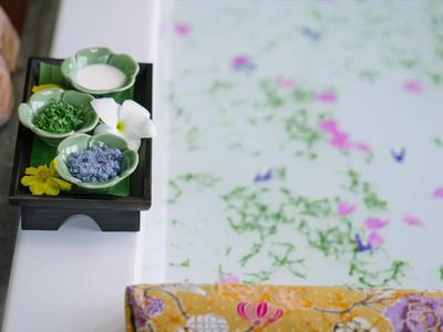 Bagno con ciotola di fiori e crema accanto a vasca da bagno piena di fiori nell'acqua