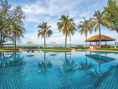 A tropical pool with palm trees and ocean view on a sunny day.