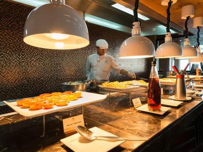 Buffet with bread rolls and drinks displayed in a modern hotel restaurant