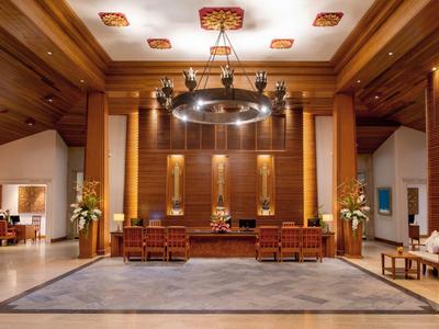 Elegant hotel lobby with wooden paneling, chandelier, and seating area.