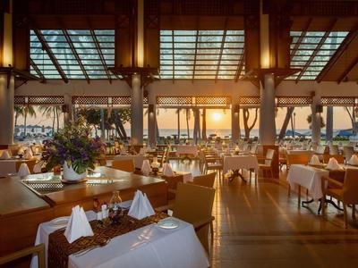 Elegant restaurant with golden lighting and sunset view.