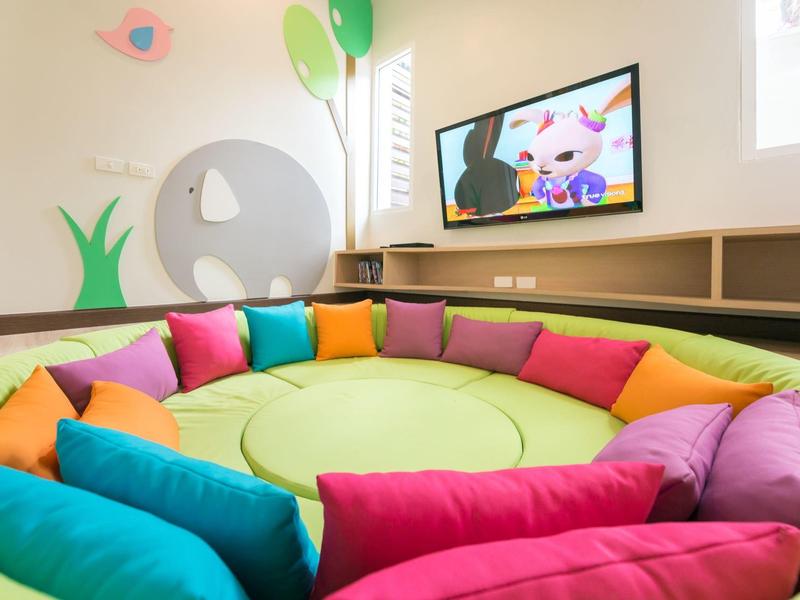 Colorful seating area with cushions in a cozy room with child-friendly decorations.