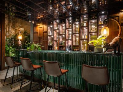 Elegancki bar z zielonym kafelkowym blatem i przytulnym oświetleniem