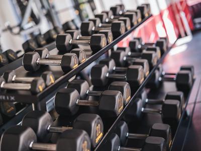 Wiele rzędów hantli o różnych rozmiarach na siłowni.