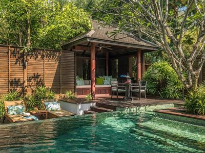 Strefa basenowa z roślinami i zadaszonym miejscem do siedzenia w tropikalnym ogrodzie