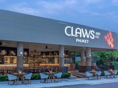 Widok zewnętrzny nowoczesnej kawiarni z miejscami do siedzenia na zewnątrz o zmierzchu.