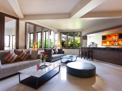 Moderně zařízená hotelová lounge s pohovkami, barem a panoramatickými okny.