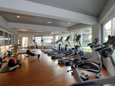 Modern gym with exercise machines and city view through large windows