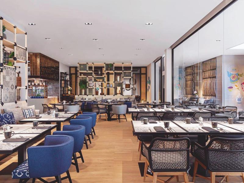 Nowoczesna jadalnia z niebieskimi krzesłami i drewnianą podłogą w hotelu.