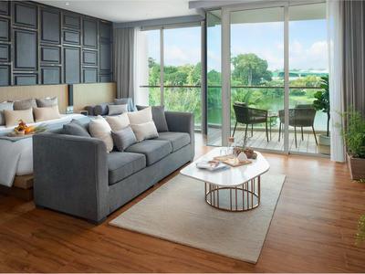 Camera d'hotel moderna con letto matrimoniale, divano grigio, balcone con sedie e vista.