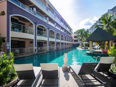 Hotel con piscina lunga, lettini e palme in una giornata di sole