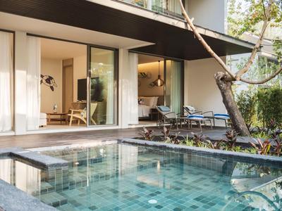 Nowoczesny dom z basenem i dużymi przesuwnymi drzwiami szklanymi otwierającymi się na ogród.