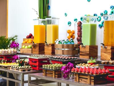 Bufet z sokami owocowymi, świeżymi owocami i małymi przekąskami na drewnianych skrzynkach.