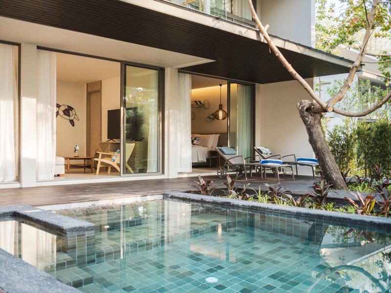 Nowoczesny zewnętrzny obszar z prywatnym basenem i miejscem do siedzenia obok szklanych drzwi przesuwnych.