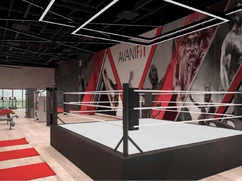Nowoczesna siłownia z ringiem bokserskim i sprzętem do ćwiczeń siłowych w hotelu