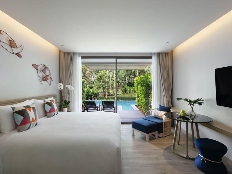 Nowoczesny pokój hotelowy z podwójnym łóżkiem, telewizorem z płaskim ekranem i widokiem na ogród z basenem