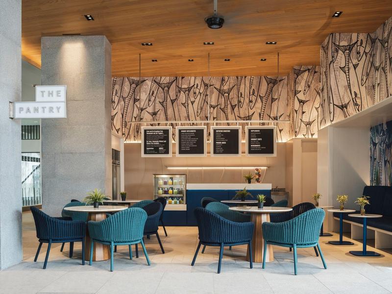 Nowoczesna sala śniadaniowa z niebieskimi krzesłami i drewnianym sufitem w hotelu.