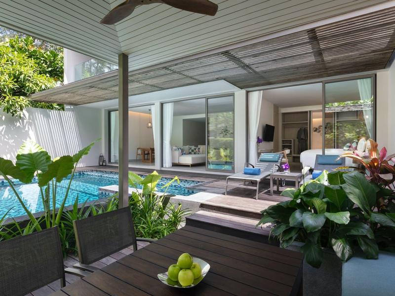 Nowoczesna przestrzeń na zewnątrz z basenem, meblami wypoczynkowymi i stołem pod zadaszonym patio.