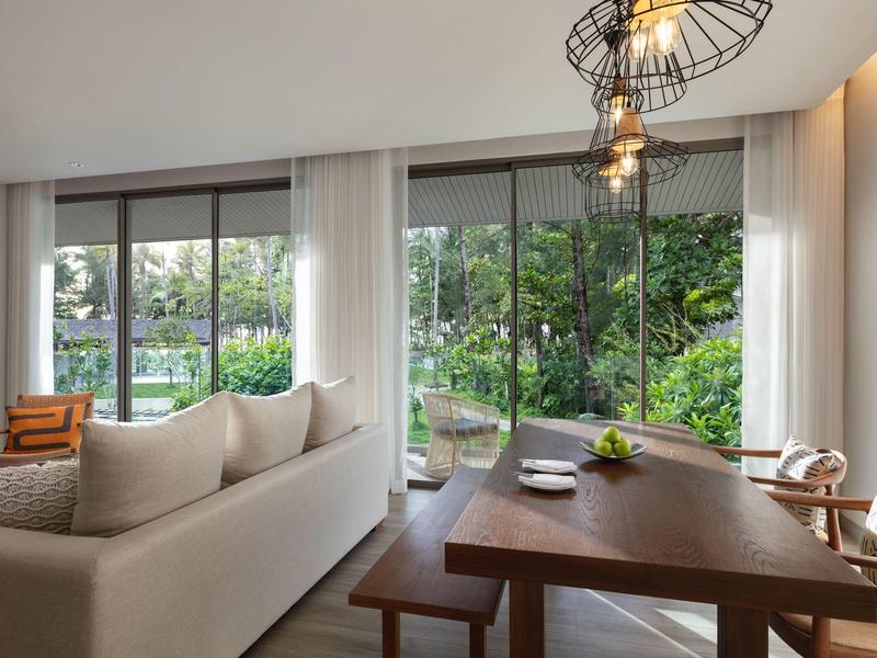 Jasny salon i jadalnia z dużymi oknami z widokiem na zieleń.