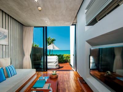 Moderní pokoj s pohodlnou pohovkou a výhledem na terasu a moře.