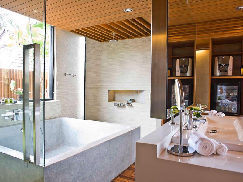 Moderní koupelna s volně stojící vanou, velkými okny a dřevěným stropem.