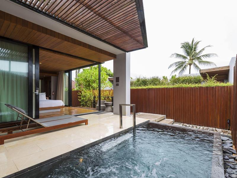 Moderní venkovní prostor s privátním bazénem, lehátky a soukromým plotem.