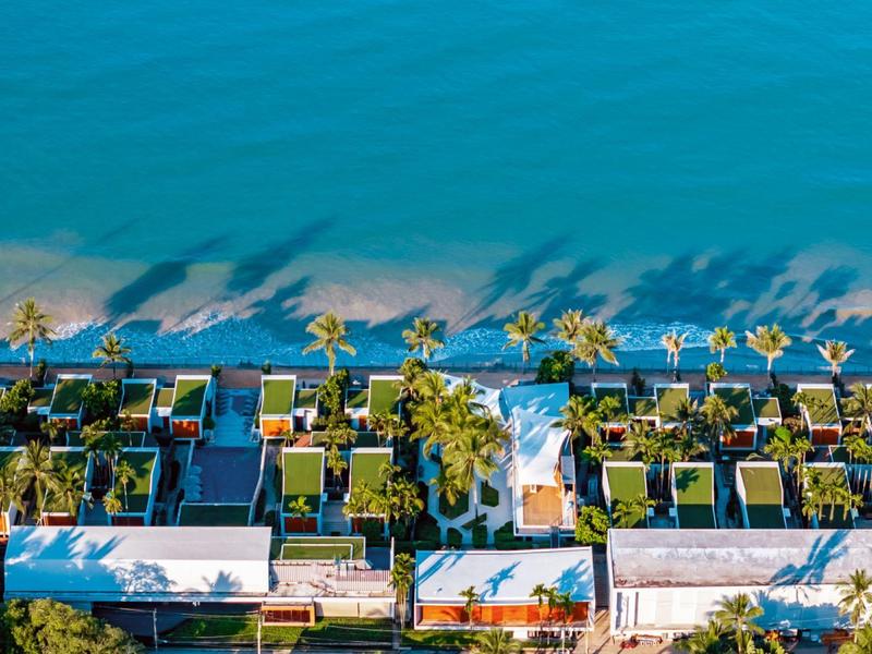 Letecký pohled na luxusní vily s bazény u tyrkysového moře