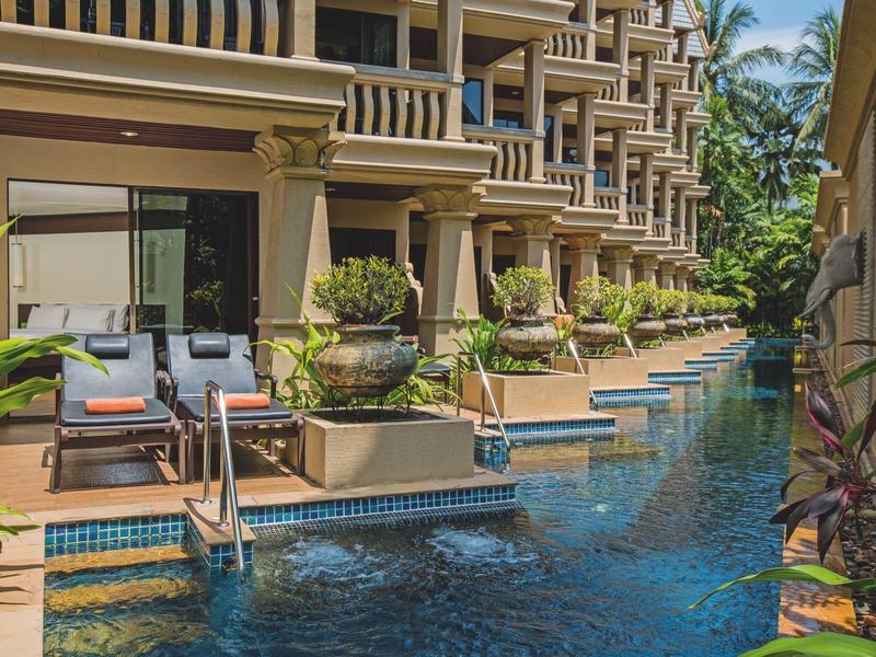 Luxuriöse Hotelzimmer mit Balkon, angrenzendem Pool und tropischer Vegetation im sonnigen Ambiente.