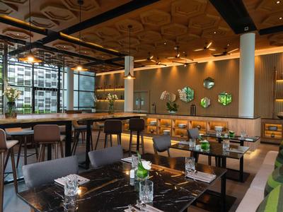 Nowoczesna restauracja hotelowa z przytulnymi stolikami, krzesłami i stylowym oświetleniem.