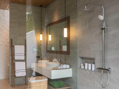 Baño moderno con ducha, lavabo, espejo y toallas en un diseño luminoso.