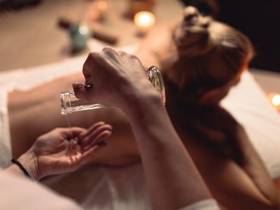Entspannende Aromatherapie-Massage mit Öl auf dem Rücken einer liegenden Person.