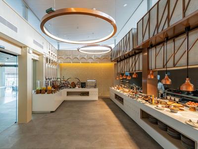 Moderní bufetová restaurace s různými jídly a stylovým osvětlením.