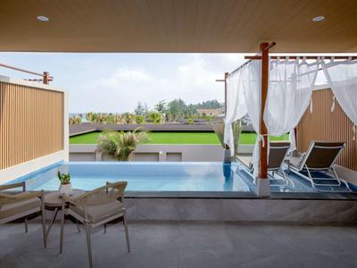 Moderní venkovní bazén s lehátky a výhledem na zelenou krajinu.