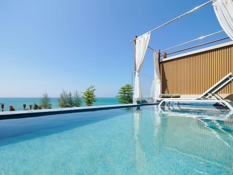 Čistá voda v bazénu s výhledem na moře pod modrou oblohou.