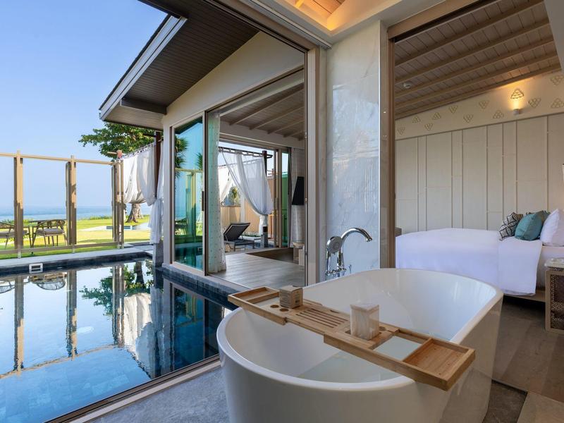 Moderní hotelový apartmán s volně stojící vanou, soukromým bazénem a výhledem na moře.