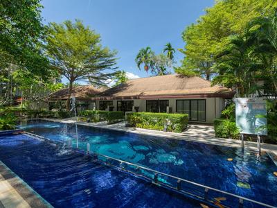 Bungaló moderno con piscina y jardín tropical bajo un cielo azul