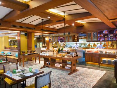 Hell beleuchteter Buffetbereich im Restaurant mit Holzmöbeln und gedeckten Tischen.