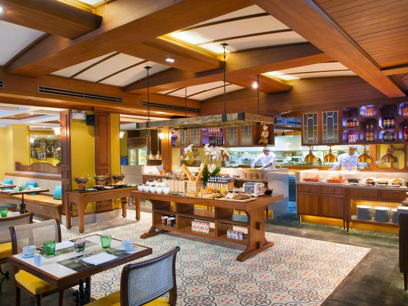 Hell beleuchteter Buffetbereich im Restaurant mit Holzmöbeln und gedeckten Tischen.