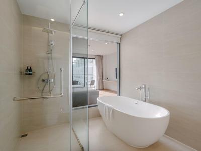 Helles Badezimmer mit freistehender Badewanne und begehbarer Dusche mit Glaswand.