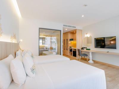 Modernes Hotelzimmer mit großem Bett, Schreibtisch und Flachbildfernseher.